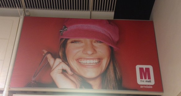 Image of inanely smiling woman as part of Mall marketing.